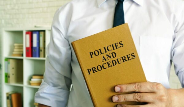 Attorney holding a book of policies and procedures