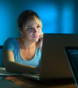 Perplexed Woman Working On PC At Night